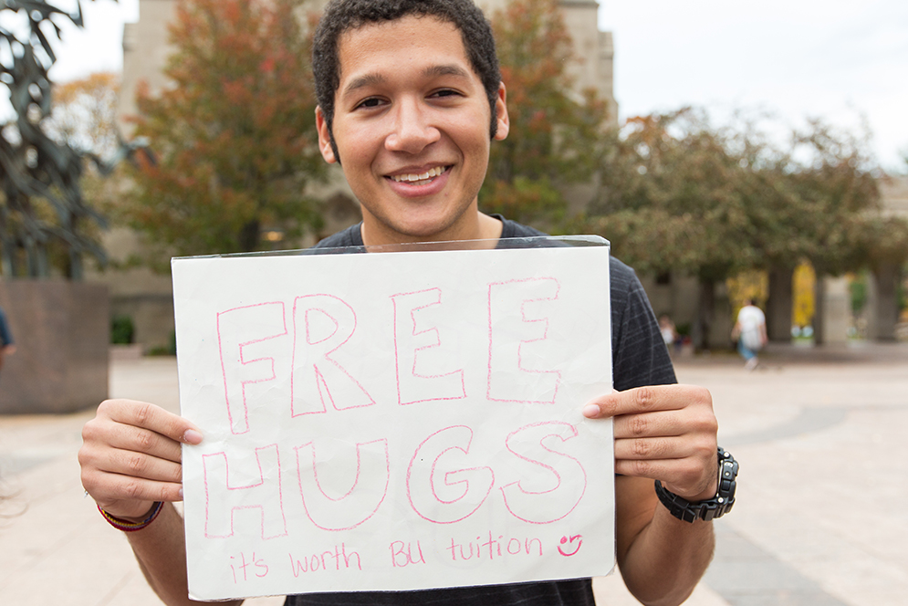 Nicholas Stapler (ENG '18) stands at Marsh Plaza for Free Hugs Friday, an effort to boost spirits of other students with hugs, high fives, and other positive energy by the group Humans United Giving Support. 
