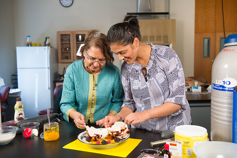 Rama Bansil, a College of Arts & Sciences professor of physics (left), and Shivangi Surana (SHA'16) try their hand at liquid nitrogen "cooking."
