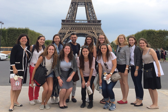 Students in the Boston University Study Abroad Paris program stand in front of the Eiffel Tower in Paris.