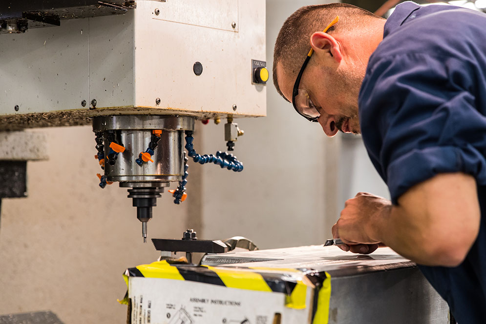 Jose Velho, Senior Experimental Machinist at the Scientific Instrument Facility, carefully augments a vacuum chamber used in the muon storage ring at Fermi National Accelerator Lab. The pieces of the chamber were fabricated in the BU SIF in the 1990s, and were recently sent back for modifications to improve the accelerator's functionality and help with the lab's search of new physics beyond the Standard Model. Photo by Dana J. Quigley 