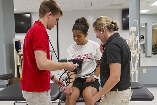 BU athletic training students Cyprien Jungels, red shirt, Amanda Fraden, white shirt and staff Erica Shaya, black shirt.