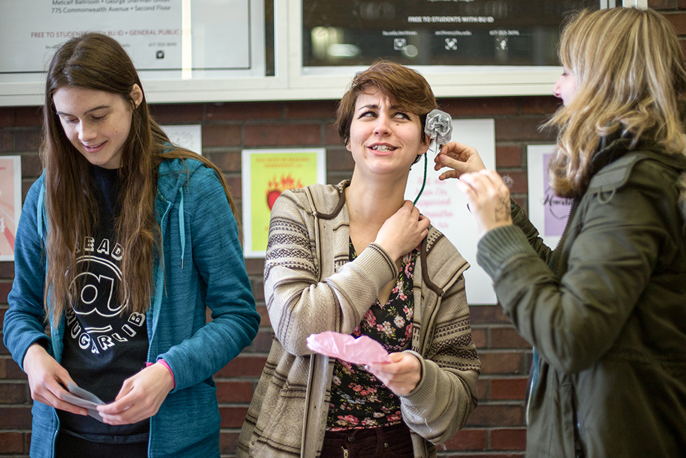 Even paper roses have thorns. Tara Kavanaugh (COM'16) reacts as Emily Sheehan (COM'16) places a paper rose in her ear. The two, along with Claire Jennings (COM/CAS'18), were making paper roses as part of the Mugar Memorial Library Valentine's Day celebration at GSU on Wednesday afternoon. Photo by Pankaj Khadka (COM'16)