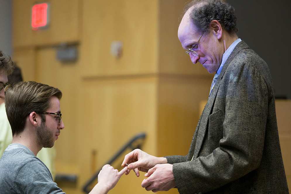 Engineers of the Ring. Ray Nagem, associate professor in the Mechanical Engineering department at BU, places a ring on the little finger of Adam Tortolanni (ENG'16) at the 32nd Annual Order of the Ring ceremony. The stainless steel ring symbolizes the oath taken earlier in the event by the prospective engineers to ethically perform their duties with utmost sincerity and upholding themselves to the ethical standards. Photo by Pankaj Khadka (COM’16)