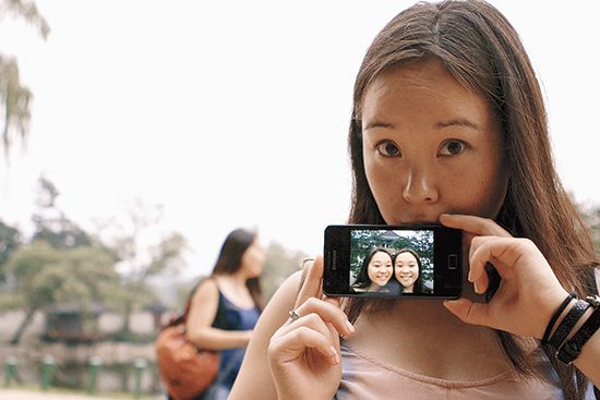 Anaïs Bordier holds up a photo of herself and her twin sister Samantha Futerman