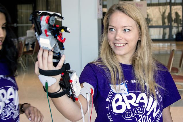 Madeline Ross (CAS '18) tries out a robotic arm controlled by her bicep muscles during Boston University's B.R.A.I.N.  (Bringing Recognition and Interest to Neuroscience) Day in the George Sherman Union. Photo by Alexandra Wimley (COM '17)