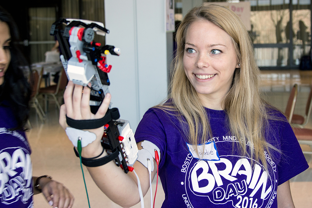 Madeline Ross (CAS '18) tries out a robotic arm controlled by her bicep muscles during Boston University's B.R.A.I.N.  (Bringing Recognition and Interest to Neuroscience) Day in the George Sherman Union. Photo by Alexandra Wimley (COM '17)