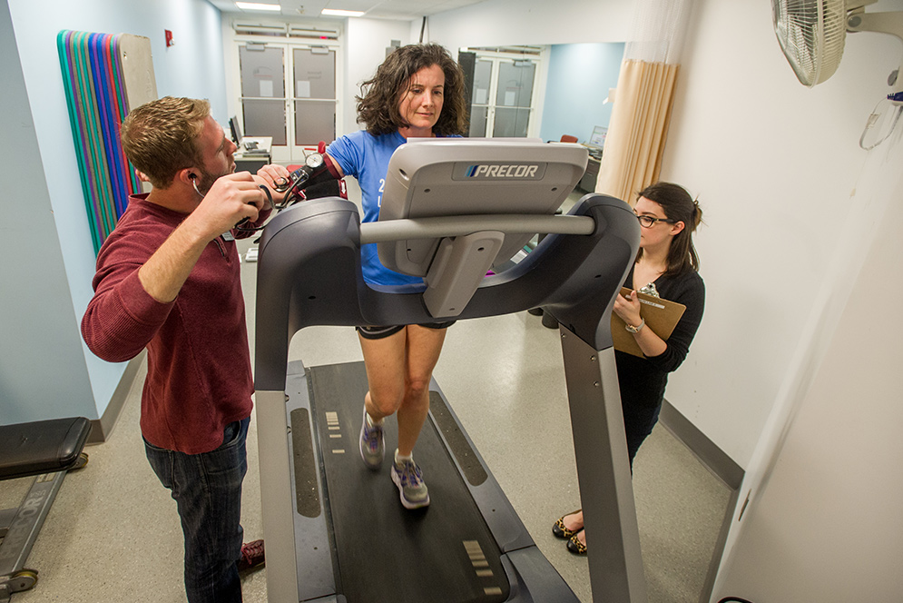 Elizabeth Dougherty walks on a treadmill while Matt Dunne monitors blood pressure and Rachel Nauer tracks heart rate during a fitness evaluation
