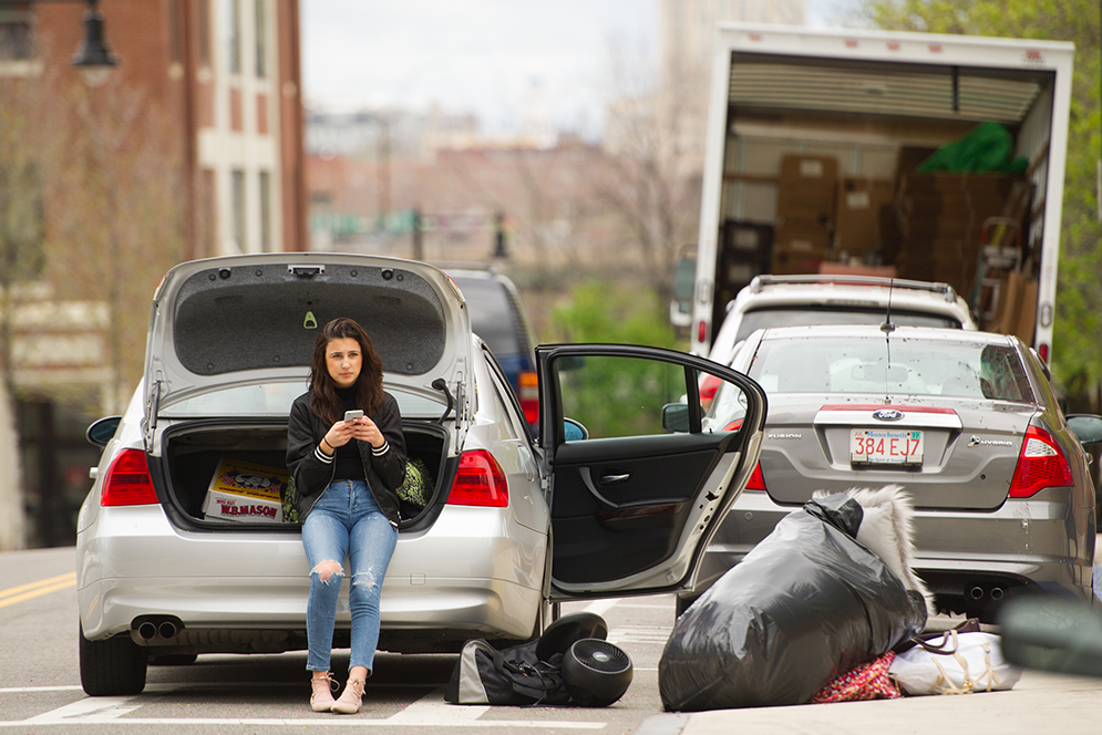 On Babcock St., Natalie Benson (CGS'19) passes the time while waiting for her roommate Taylor Ventricle (CGS'19) May 4, 2016 so the two could finish packing Benson's car with their west campus dorm room belongings. Benson would be dropping Ventrice at the airport for Boca Raton before heading home to Andover, MA for the summer. Photo by Cydney Scott