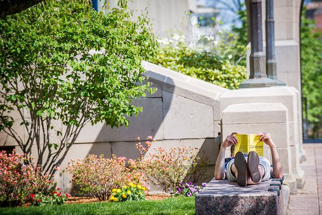 Student relaxing and reading on the Boston University Charles River Campus