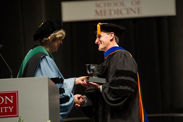 Dean Karen Antman presents Professor John Otis with the Stanley L. Robbins Award for Excellence in Teaching at the MD/PhD commencement at Agganis Arena May 12, 2016. Photo by Cydney Scott 
