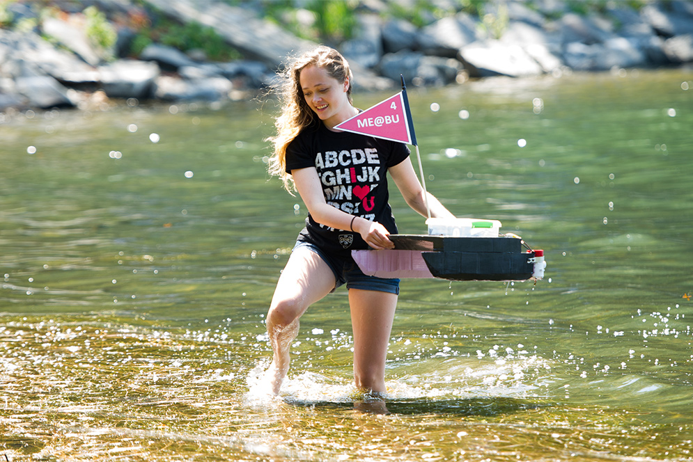 a bu student retrieves a jet propelled boat from Jamaica Pond