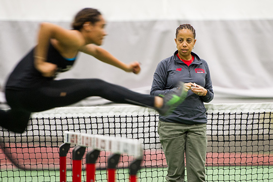 Robyne Johnson, BU’s track and field director watches team members run hurdles during a team practice