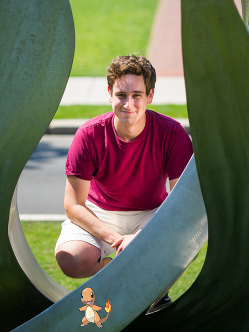 portrait of college student Teddy Kahn with Pokemon character Charmander