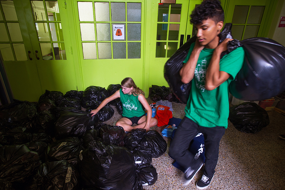 FYSOP volunteer Kate Cropp (CAS'2) and Matthew Boykin (SAR'20) organize branded clothes to be sold at elementary school
