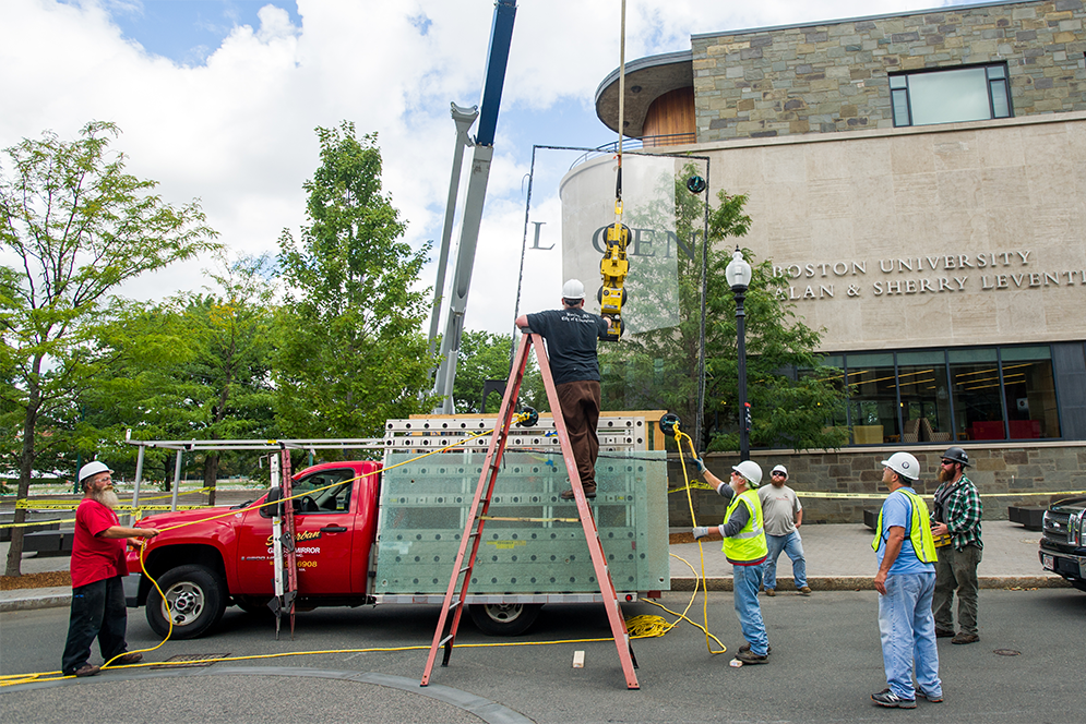 Workers from Suburban Glass replace a broken window pane at Boston University Alan and Sherry Leventhal Center