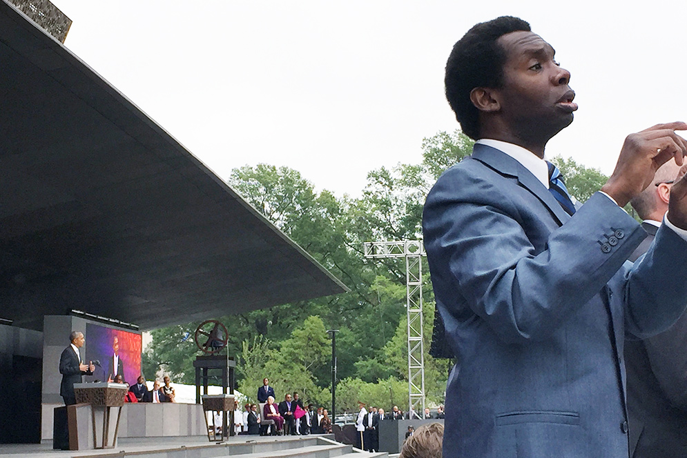 Christopher Robinson interprets the words of President Barack Obama in front of a crowd at the opening of the National Museum of African American History