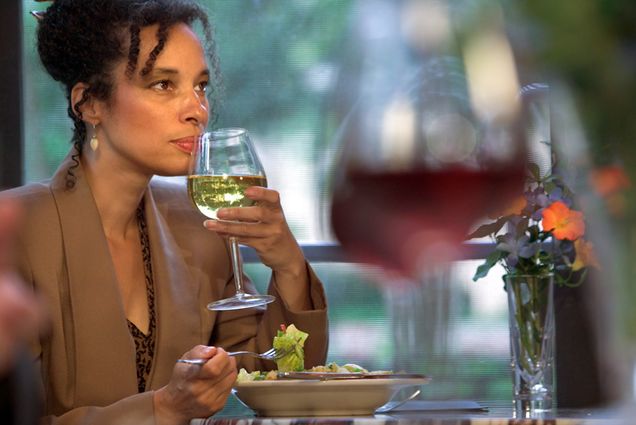 African American woman drinking wine with dinner