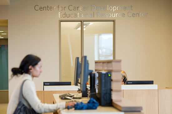 A student looking up information on a computer in the BU Career Development Center