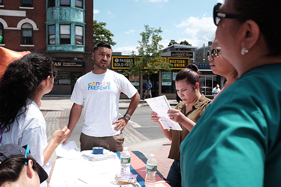 Mario Paredes (LAW’18) standing outside at a booth helping people register