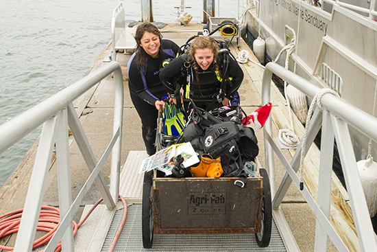 Mollie Yacano (CAS’17) (left) and Madison Montgomery (CAS’17) with a cartful of the gear they use to dive