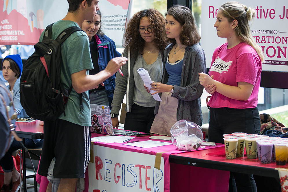 Cameron Dacey (CGS '20), Noelle Monge (CAS '20), Rae Bettenweiser (CAS '19) and Phoebe Nelson (CAS '19) speak to a student about registering to vote