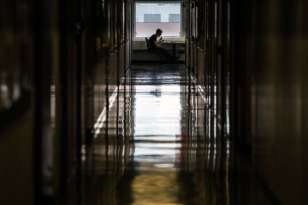 a shot of a long hallway with a student studying 