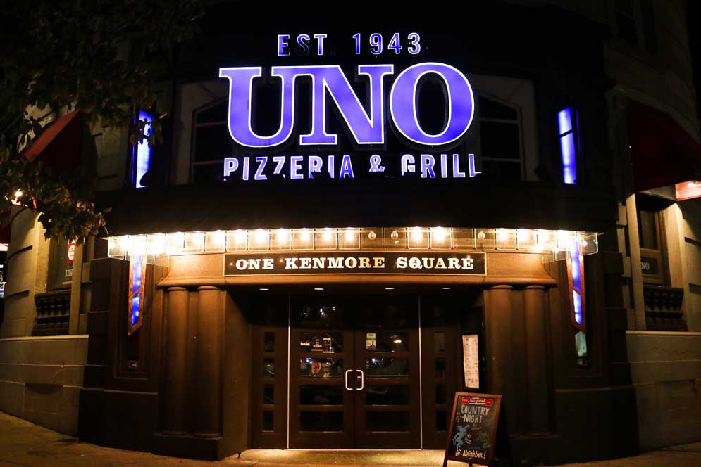 The exterior of UNO pizzeria lite up at night