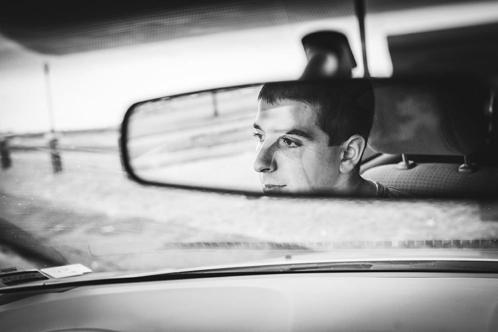 Photo of Skylar through the rearview mirror of his car