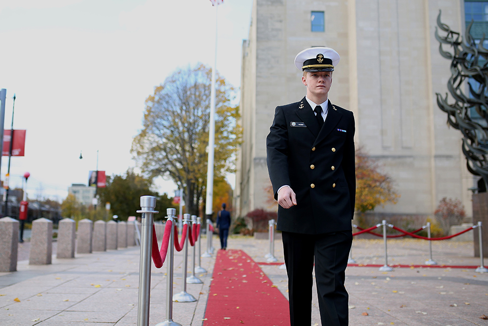 Sam Gilbert (CAS’19), a member of Boston University Reserve Officers’ Training Corps, marches in front of a memorial at Marsh Plaza during Veterans Day