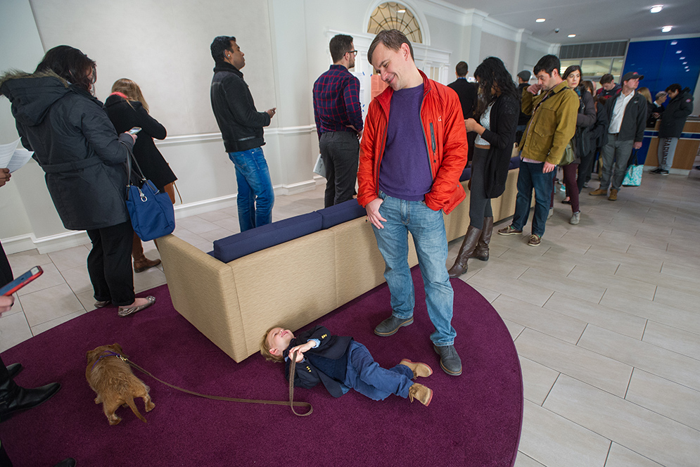 Four-year-old Felix Sergeev lays on the ground while his dad Rinat Sergeev looks over him