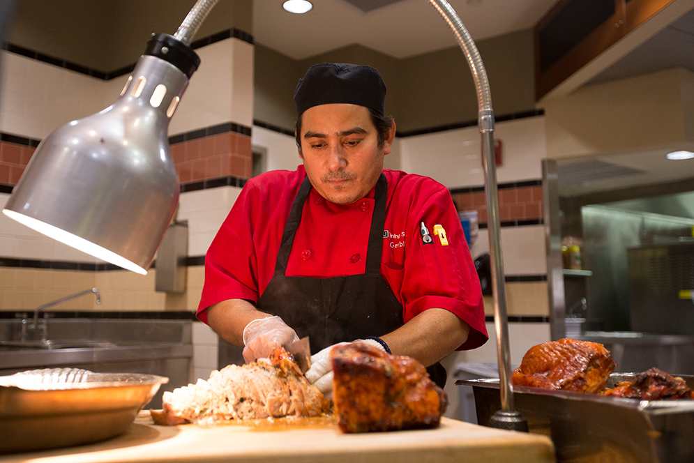 Gerbis Pena carves a turkey breast during the Thanksgiving Dinner