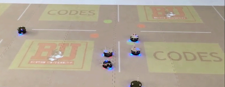 Working in the Robotics Laboratory, Cassandras and his team use mobile robots to run a live simulation of smart vehicle technology by projecting a city grid on the floor. The robots respond to traffic lights (the red and green dots) and each other when moving through intersections. Provided by CODES Laboratory
