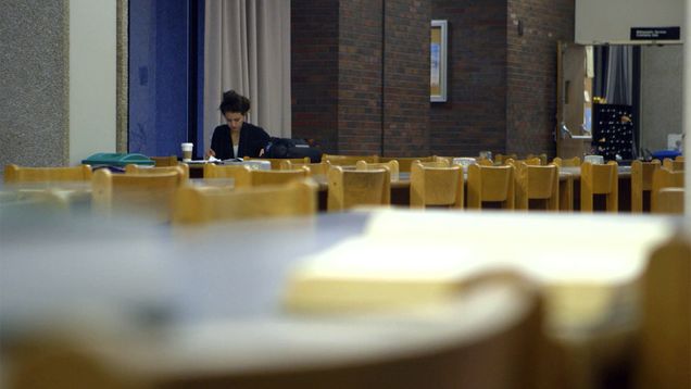 Photo of student studying in empty library