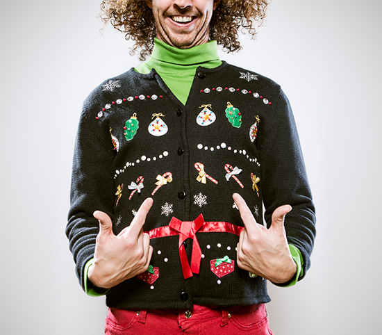 Man showing off ugly holiday sweater.