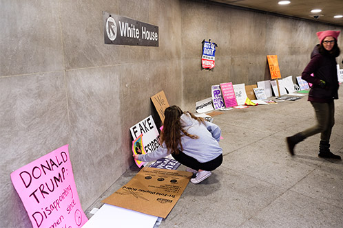 Women’s March on Washington signs left under a White House directional