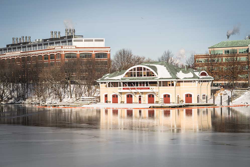 A light snow covers the Boston University DeWolfe Boathouse along the Charles River