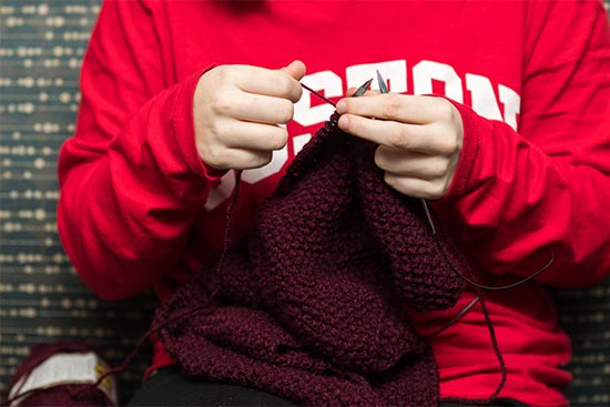 A student member of the BU Knitting Club, a Boston University club open to all students who crochet, weave, spin, or do embroidery