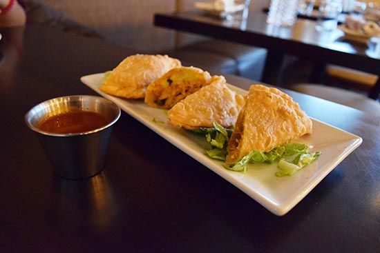 The chicken empanadas are stuffed with a blend of meat and vegetables and served on a bed of lettuce.