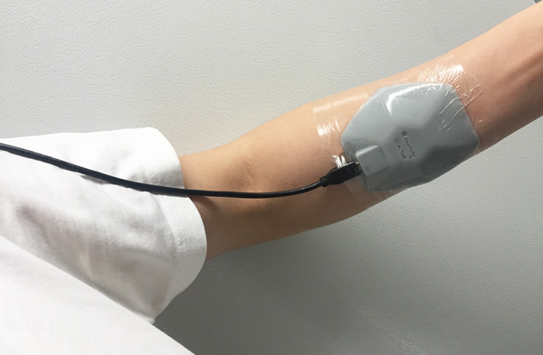 Noninvasive wearable biomedical imaging device for breast tumors being tested on the wrist of a healthy patient