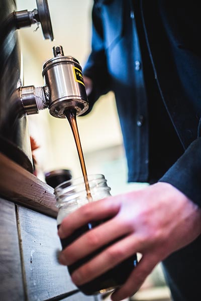 Brian Woerner pours a sample from Follow The Honey’s stock of dozens of different honeys from all over the world