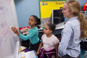 Aurora Kesseli with third-graders Amaria Smith (left) and Cassandra Riley as they work on an experiment at the Girls Science Club.