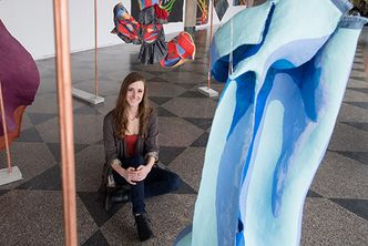 Erin Kerbert with her sculptural paintings at the 808 Gallery.