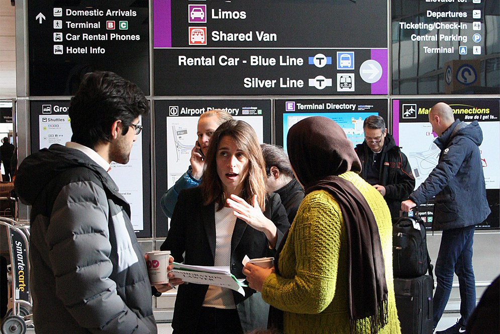 LAW lecturer Sarah Sherman-Stokes (center) and two LAW students met with international flight passengers arriving at Logan Airport January 30 to ensure compliance with a federal court order preventing those being detained in US airports from being deported. Photo by Sarah Miller