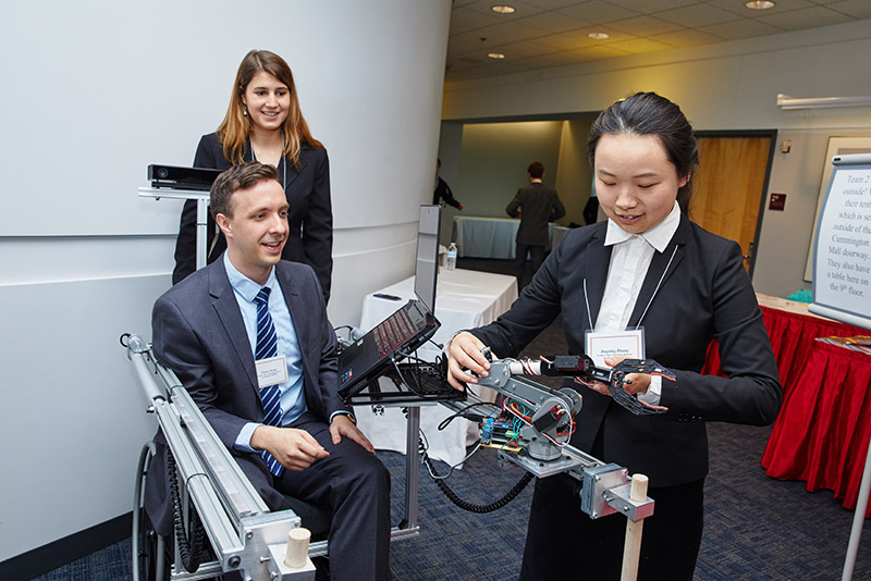 Team 6 members Kathleen Lewis (from left), Victor Weiss, and Jingning Zhang with DORI, the Door Opening Robotic Intelligence, during the ECE Day demonstrations.