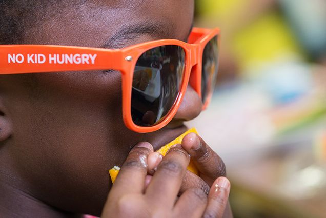 african american child eating an orange slice