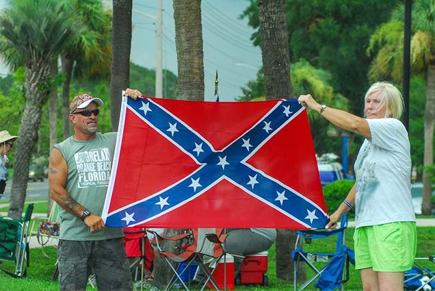 Attendees hold a Confederate Flag during the Florida Southern Pride Ride parade.