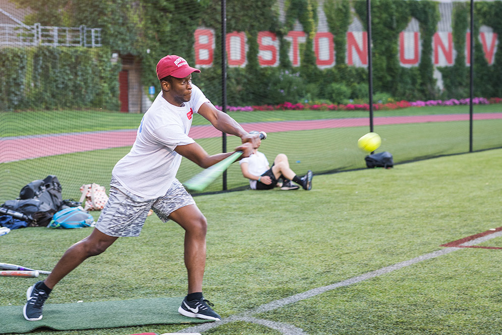 School of Public Health student Ola Omotowa swings at a pitch during a BU Summer Softball League game