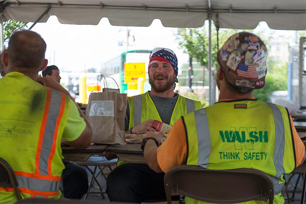 Construction workers working on the Commonwealth Avenue Bridge replacement project take a lunch break