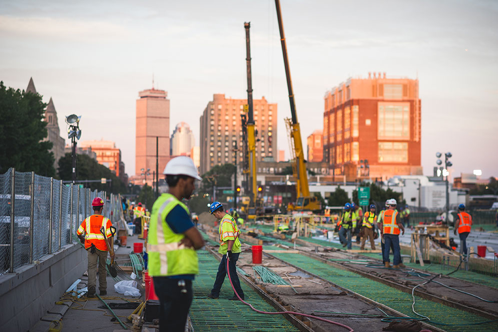 skyline at dusk construction workers in the forefront