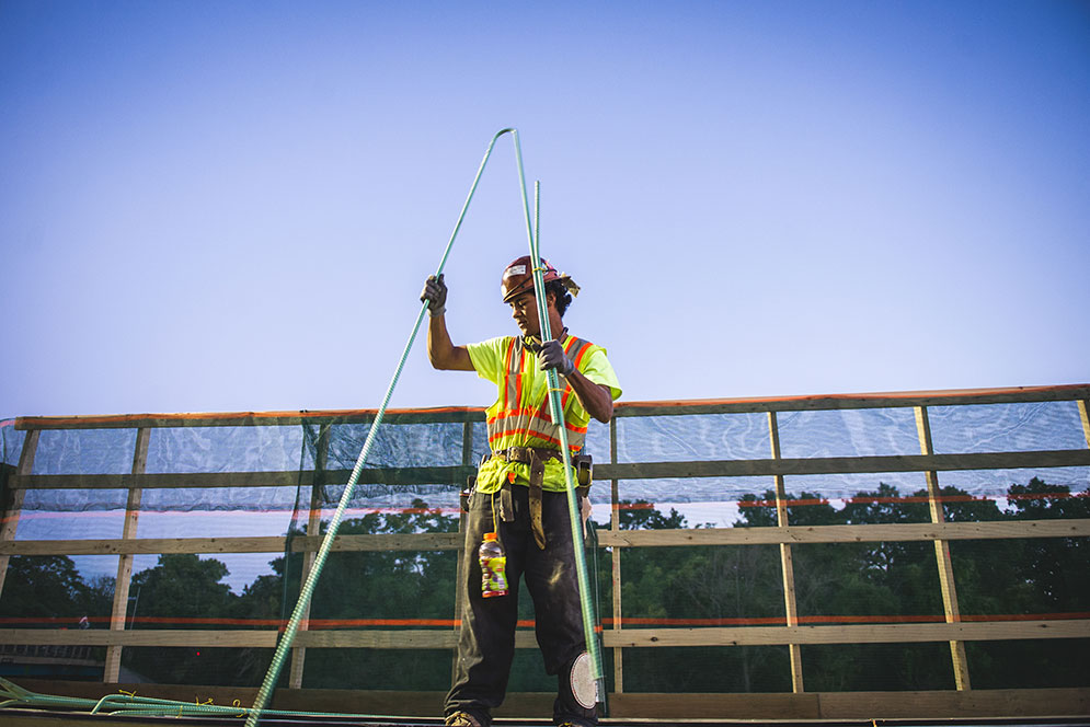 lone construction worker measuring beams